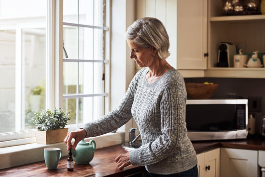 Time to take my medicine. Cropped shot of a relaxed senior woman preparing a cup of tea with CBD oil inside of it at home during the day.